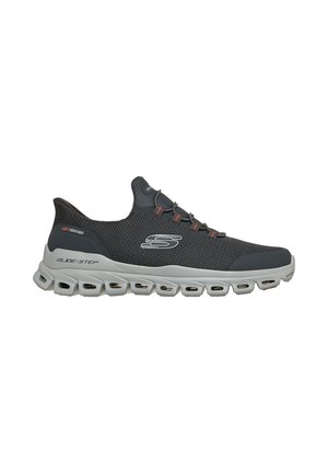 Schwarzer Slip-On Sportschuh mit grauer belüfteter Sohle, der seitlich mit "S" und mit dem Text "Glide-Step" nahe der Ferse versehen ist.
