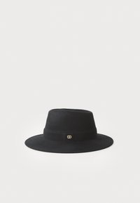 Cappello fedora in feltro nero a larga tesa con una fascia stretta e un piccolo emblema ovale dorato su sfondo bianco uniforme.