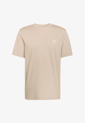 Beżowy bawełniany T-shirt z krótkimi rękawami, okrągłym dekoltem i małym białym logo Adidas na lewej piersi. Miękka tekstura, casualowy krój.