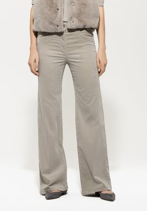 Graue weit geschnittene Hose mit einer glatten, weichen Textur und gestickten Details. Kombiniert mit grauen Schuhen und einer passenden Weste.