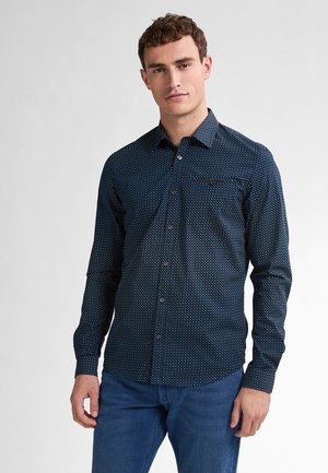 Camicia abbottonata blu scuro con pois bianchi, maniche lunghe e taschino sul lato sinistro del petto; tessuto liscio con colletto semplice.