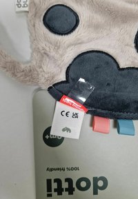 Pehme nõtke pilvetooted hallis ja beežis värvitoonis, millel on sinised ja roosad sildid. Omab ümarat tekstuuri ning hoolduslabelit, millel on trükitud "100% sõbralik".