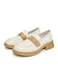 Mocassins en cuir verni blanc avec une bride tan et un détail de logo. Semelle en caoutchouc épaisse avec des accents striés pour une meilleure adhérence.