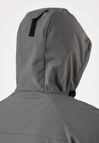 Veste grise à capuche avec bande Velcro noire à l'arrière de la capuche, vue de dos sur un fond blanc uni.