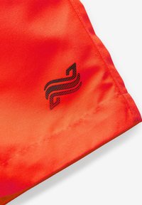 Shorts atletici rossi realizzati in un tessuto liscio e leggero. Presentano un logo nero sull'orlo con un design elegante e cuciture a contrasto.