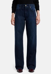Jeans ampi di colore blu scuro realizzati in denim, caratterizzati da un girovita alto, bottone in rame e design a cinque tasche per dettagli funzionali.