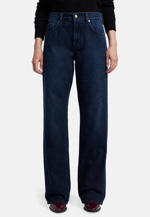 Jean large en denim bleu foncé, avec une taille haute, un bouton en cuivre et un design à cinq poches pour des détails fonctionnels.