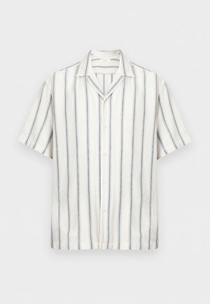 Chemise blanche à manches courtes avec boutons, dotée de fines rayures verticales noires et bleues, et d'un col camp, présentée sur un fond uni.