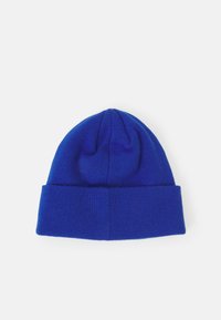 Blå strikket lue med brett. Laget av mykt stoff, med ribbestruktur og en lett avsmalning på toppen.