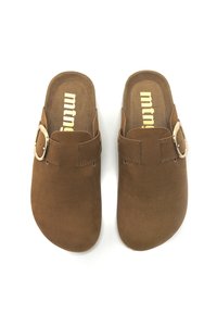 Sabots en daim marron avec un bout rond et un design à enfiler. Dotés d'une seule sangle ajustable avec une boucle métallique. Doublure intérieure douce.