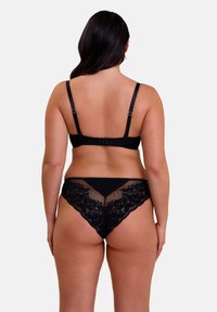 Soutien-gorge en dentelle noire et string assorti. Comprend des bretelles réglables et des détails en dentelle florale sur le string. Tissu lisse et texture délicate.