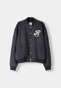 Navy blue bomber jacket in soft fabric, featuring white logo on chest, metal snap buttons, and ribbed cuffs and hem. Two side pockets.