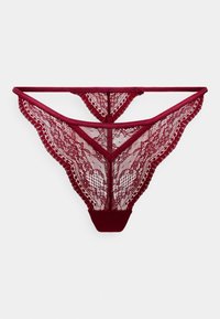 String en dentelle bourgogne avec des motifs délicats et complexes et un bord en tissu doux. Présente une forme triangulaire et une couverture minimale à l'arrière.