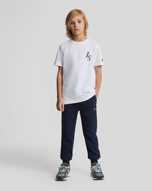 Baltas kokvilnas T-krekls ar tumši zilu "LS" logotipu, pāris ar tumši zilām sporta biksēm. Pelēki un melni sporta apavi ar dzelteniem aksesuāriem.