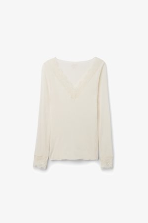 Long-sleeve cream blouse with V-neckline and lace trim on neckline and cuffs, displayed on a white background.