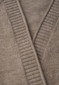 Cárdigan marrón claro con un diseño de cuello en V; presenta una textura acanalada en los bordes y una apariencia suave y tejida en todo el prenda.