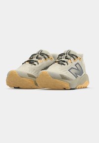 Adidași de culoare gri deschis, cu tălpi medii, partea superioară texturată din plasă, accente negre și portocalii, și talpă durabilă din gumă pentru o aderență sporită.