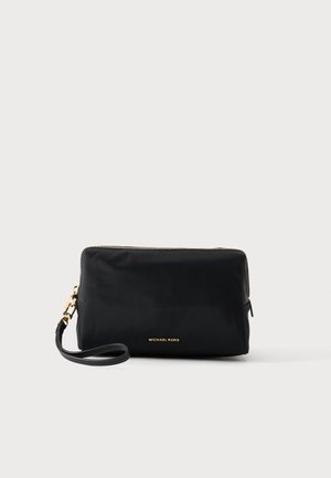 Pochette rectangulaire noire pour poignet avec fermeture éclair dorée et logo, sangle détachable sur fond clair.