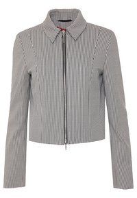 Veste courte à motif noir et blanc avec fermeture éclair, col pointu et manches longues, présentant un tissu texturé.