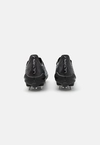 Mustad must futboliketsad musta tekstureeritud siledast pealmisest osast, voolava disainiga ning viis metallist nupukest talla all haarduvuse tagamiseks.