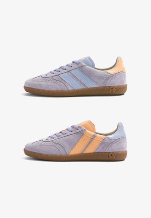 Deux baskets en daim lavande avec semelles en gomme, l'une avec des rayures bleu clair et un talon, l'autre avec des rayures orange et un talon, toutes deux avec des lacets.