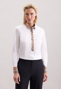 Weißes Langarmhemd mit einem karierten Kragen und Manschetten in Beige, Braun und Schwarz. Verfügt über eine Knopfleiste vorne. Taillierte Passform.