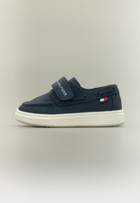 Σκούρα μπλε αθλητικά παπούτσια με ιμάντα βέλκρο, ανάγλυφη επιφάνεια και λευκή ελαστική σόλα. Διαθέτουν λογότυπο και μικρή τριχρωμία στη πλευρά.