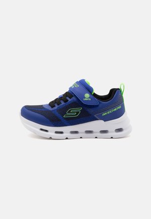 Baskets Skechers pour enfants bleu et noir avec des accents verts, semelle blanche rembourrée, bride auto-agrippante étiquetée "Lights," et lacets.