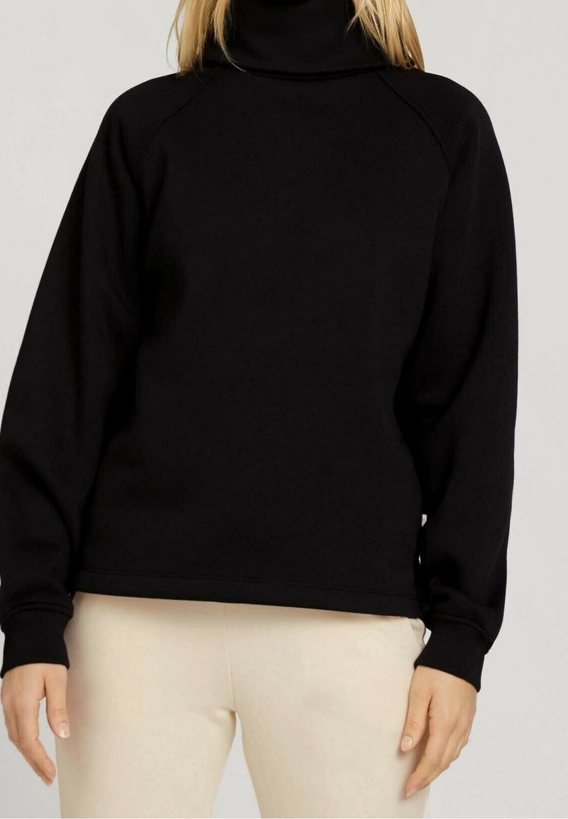 Černá roláková mikina s raglánovými rukávy, texturední tkaninou a žebrovanými manžetami. Navržena v uvolněném střihu a s minimálními detaily.