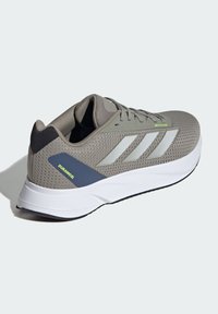 Scarpa da ginnastica grigia con tomaia in mesh, tre strisce bianche e un accento navy con il testo "Duramosl". Suola intermedia bianca e suola esterna nera.