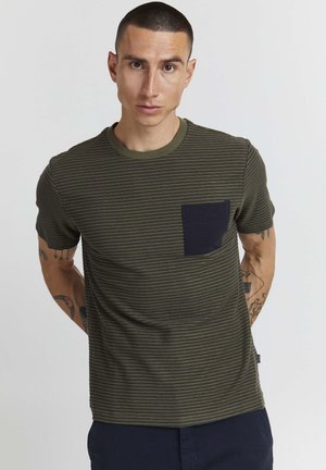 T-shirt à manches courtes olive avec un motif rayé bleu marine foncé et une poche sur la poitrine. Encolure ronde côtelée et texture lisse.