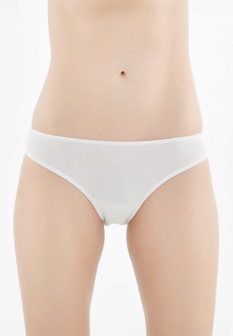 Bikini in cotone bianco con una texture liscia, design a vita bassa e elastico in vita, caratterizzato da cuciture minime e senza motivi visibili.