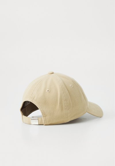 Beige baseball cap with a curved brim, made of cotton. Features a fabric strap and metal clasp for adjustable fit at the back.