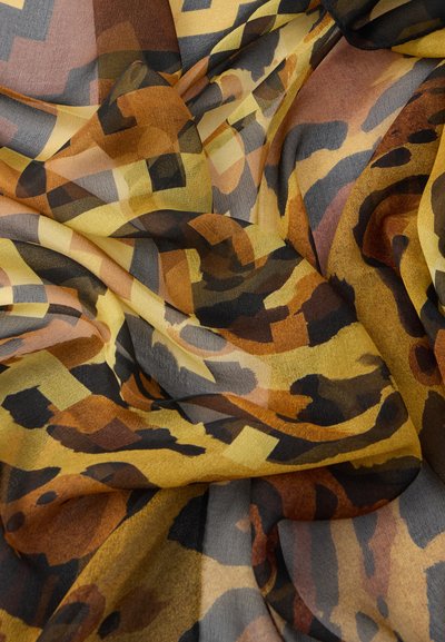 Ελαφρύ, στρωματοποιημένο ύφασμα με γεωμετρικό και ζωικό σχέδιο σε ζεστούς τόνους κίτρινου, καφέ και μαύρου με απαλή υφή.