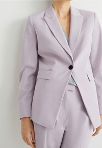 Jasnolawendowa marynarka wykonana z teksturowanej tkaniny, z pojedynczym czarnym guzikem, klapami i wyraźnie uformowanym krojem.