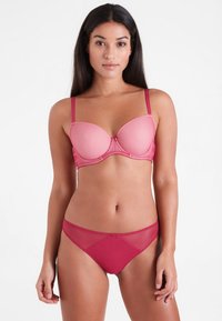 Rood gestippeld mesh lingerie set met een gevoerde beha met verstelbare bandjes en een bijpassende low-rise slip met doorzichtige accenten.