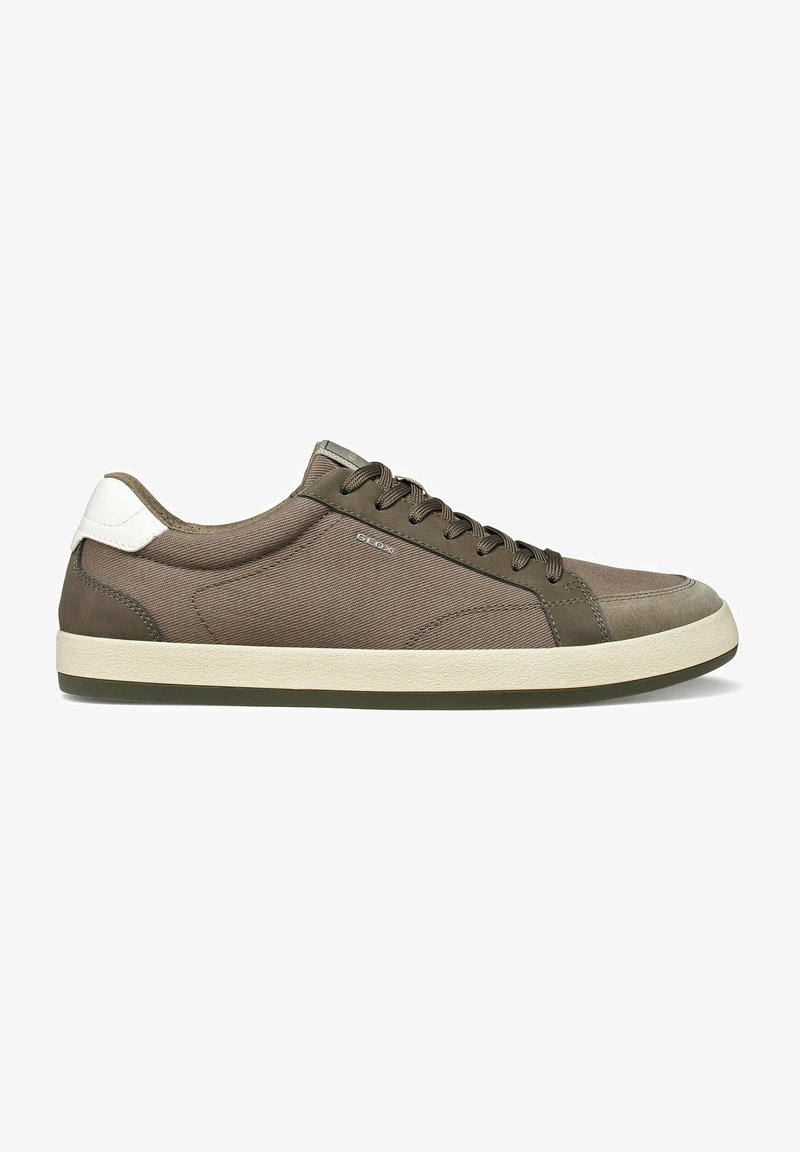 Zapatilla casual de caña baja en tela y cuero marrón con parche blanco en el talón y suela de goma color blanco roto, vista lateral.