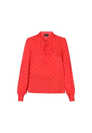 Blusa rossa a maniche lunghe con colletto annodato, caratterizzata da una fantasia a pois e un tessuto leggero e morbido. I polsini hanno un design arricciato.
