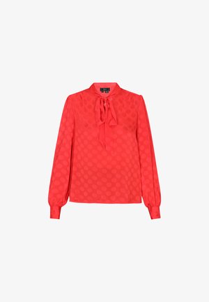 Blusa rossa a maniche lunghe con colletto annodato, caratterizzata da una fantasia a pois e un tessuto leggero e morbido. I polsini hanno un design arricciato.