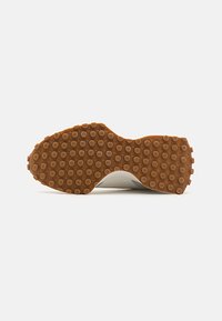 Talpă din cauciuc cu o textură anti-derapantă, prezentând modele rotunde, combinată cu un design elegant și conturat într-o culoare deschisă.