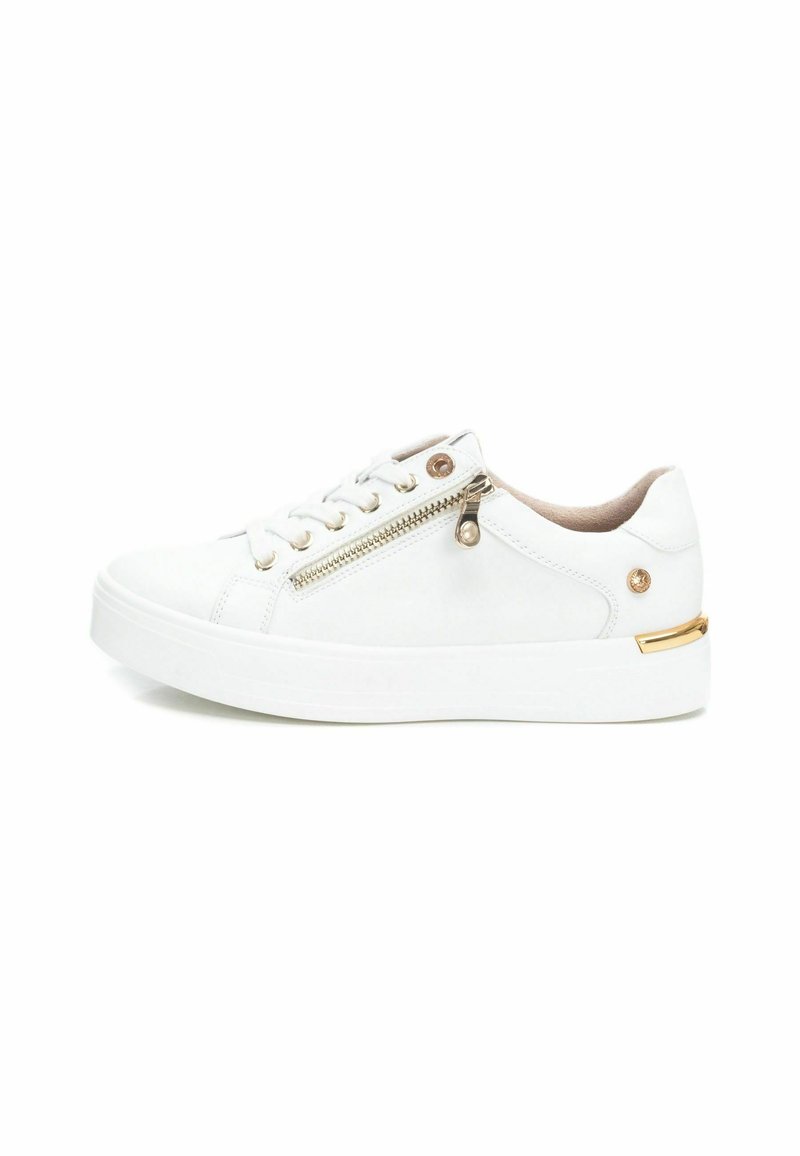 Zapatilla blanca con una textura suave, que presenta una cremallera lateral, detalles en dorado y una suela de goma blanca. Diseño bajo y casual.