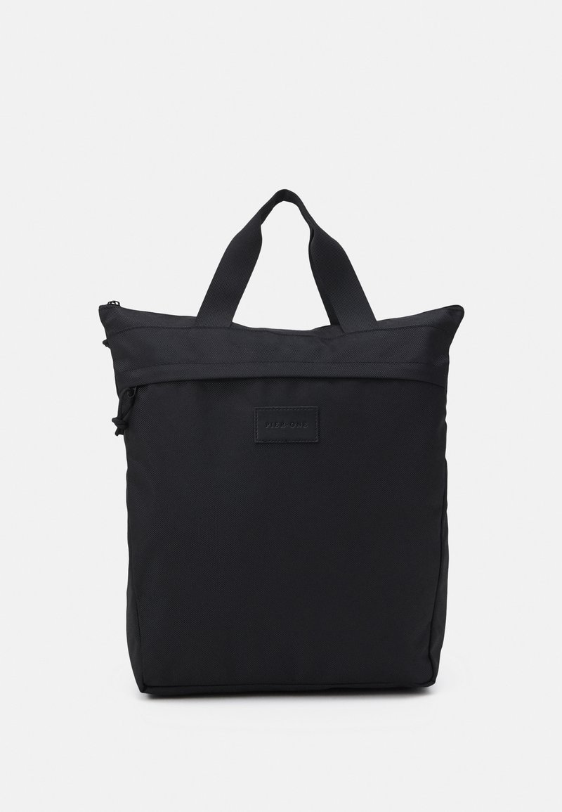 Sac cabas rectangulaire noir avec double poignée et fermeture éclair sur le dessus, en tissu texturé avec une petite étiquette cousue à l'avant.