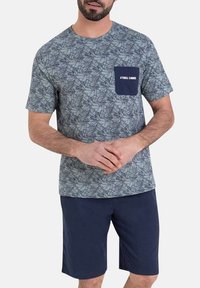 T-shirt à manches courtes en gris et bleu à motif avec une poche marine ornée de texte blanc. Associé à un short marine. Coupe standard.