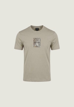 T-shirt beige chiaro a maniche corte con una piccola stampa rettangolare di foglia di palma e la scritta "Armani Exchange" centrata sul petto.