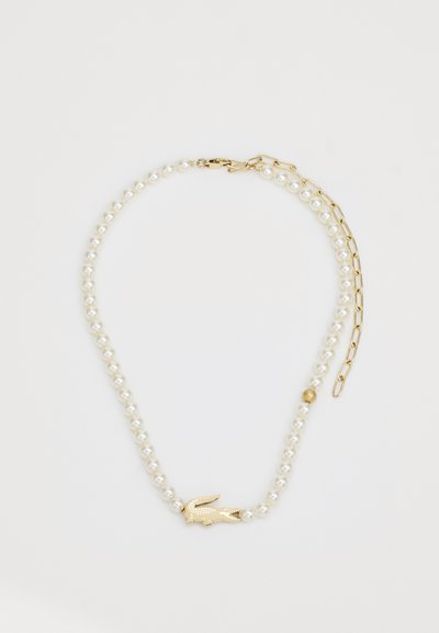 Collier de perles avec des accents dorés, présentant un fermoir en or et un charme animal doré décoratif. Perles lisses et rondes dans un motif uniforme.