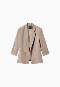 Blazer beige clair pour femme avec des revers en pointe, ouverture à l'avant, deux poches plaquées à l'avant et des manches retroussées à trois quarts.