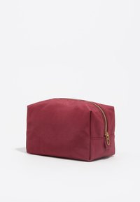 Bolso de cosméticos de tela roja con forma rectangular, cremallera dorada y detalles de costura. Textura suave y diseño estructurado.