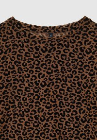 Top con stampa leopardata che presenta una base marrone con macchie nere, realizzato in tessuto morbido. Design con collo rotondo e maniche corte.