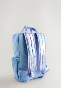 Sac à dos bleu clair avec surface texturée, sangles réfléchissantes et poche latérale. Dispose d'une poignée renforcée pour le transport.