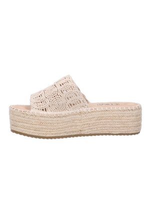 Sandalias de cuña con una cinta tejida y texturizada en color beige que presenta recortes circulares. La plataforma está hecha de yute, mostrando un aspecto natural y rústico.